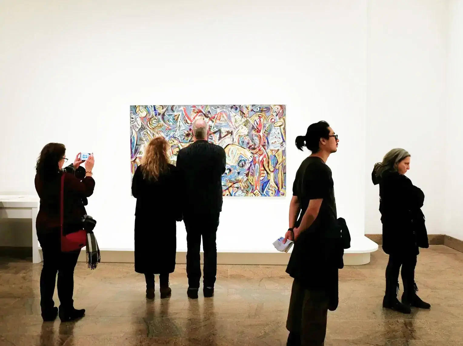 Arts and Culture — Gallery visitors viewing a large painting on a white wall