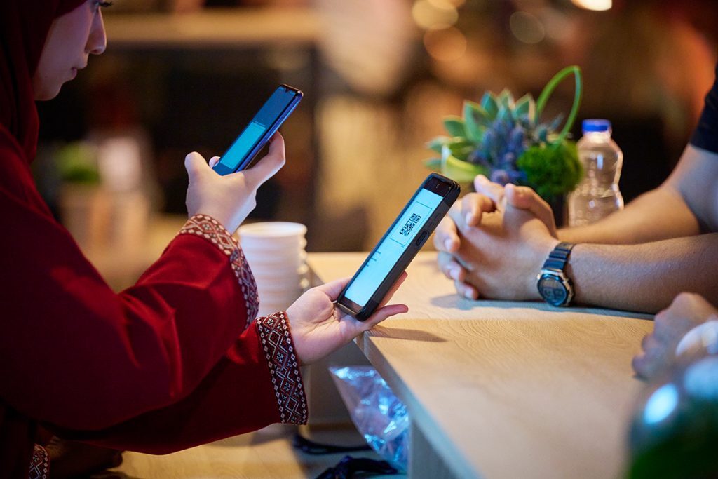 A Match Hospitality hostess uses the zkipster app to scan a guest's QR code for check-in at a sporting event